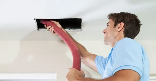 HVAC tech cleaning air ducts